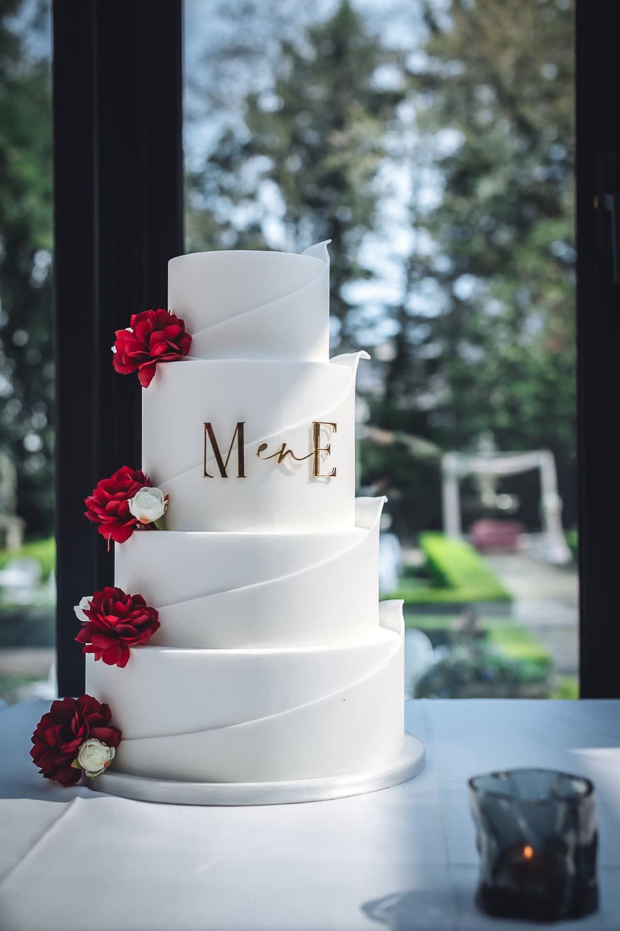 Bruidstaart met monogram en rode rozen in Villa 1855